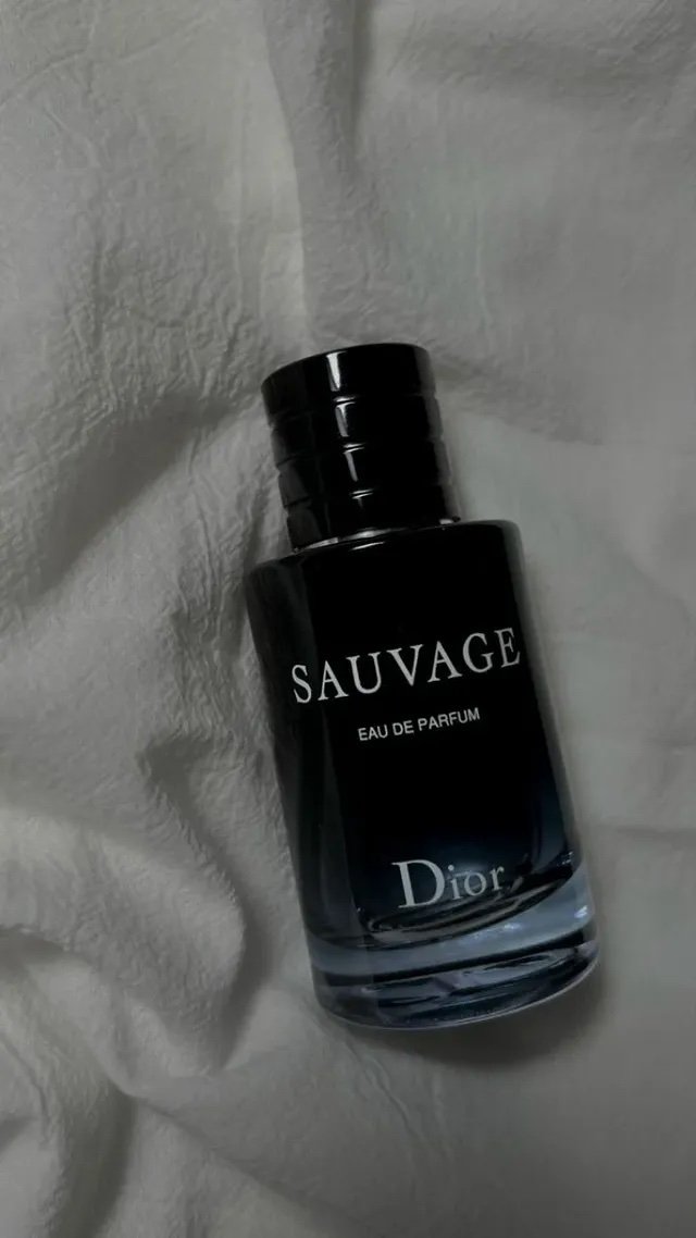 Perfume Sauvage de Dior sobre sábanas blancas